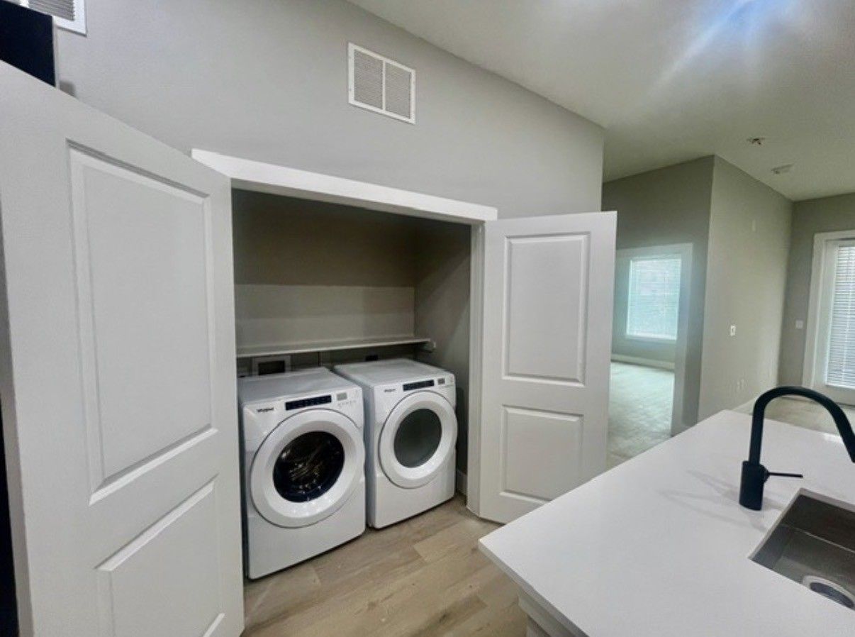 Laundry closet with stacked washer and dryer in a bright modern home laundry room