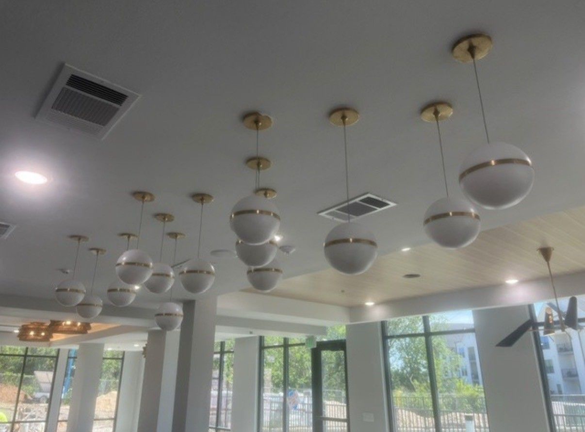 Ceiling with hanging globe pendant lights and skylights in a bright modern indoor space