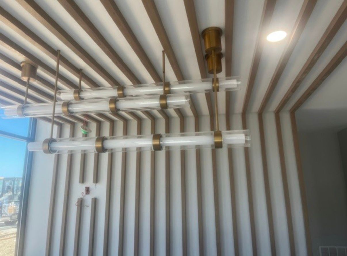 Modern ceiling with white and gold striped panels and hanging gold light fixtures
