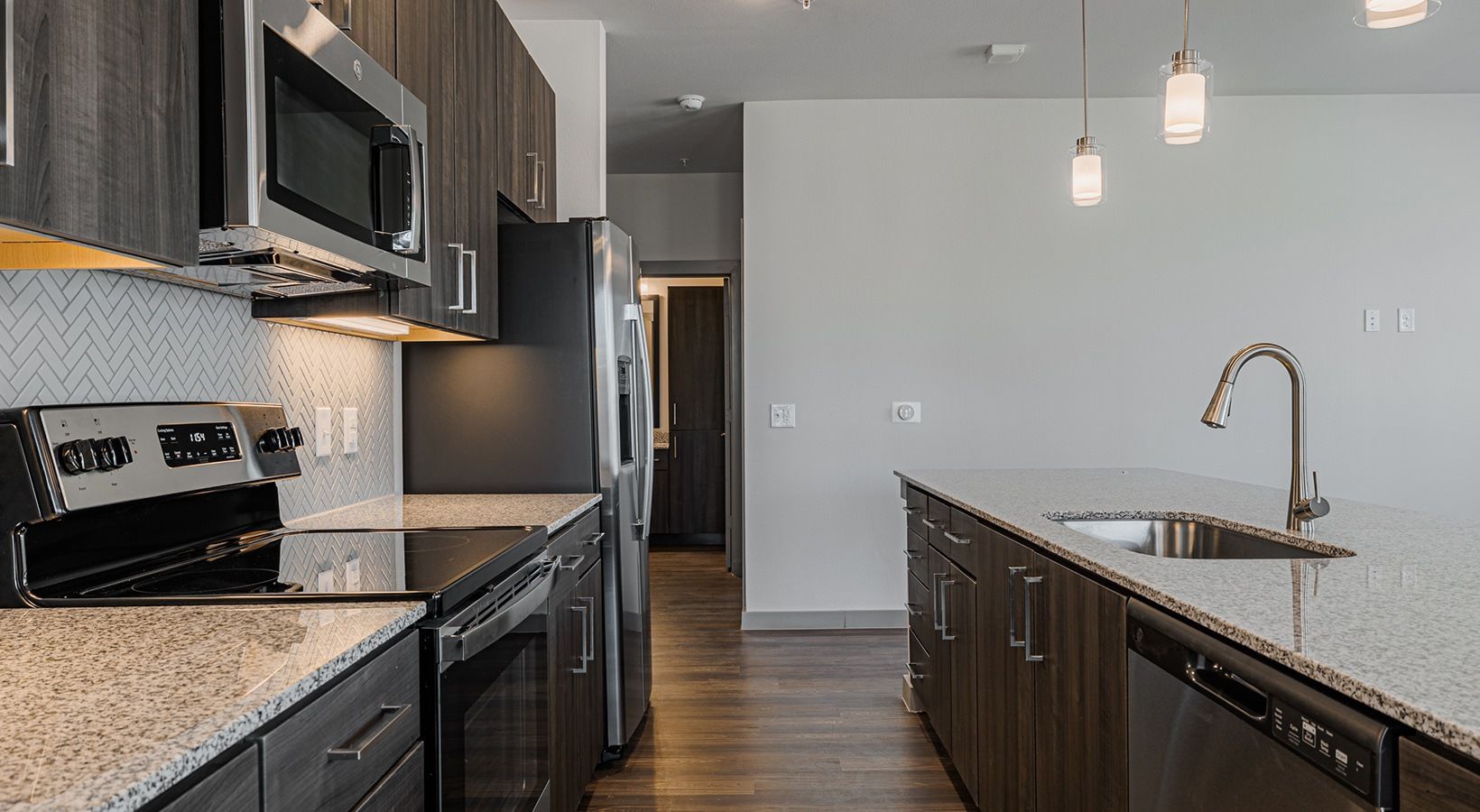 Modern kitchen with black appliances, dark cabinets, and a white island countertop