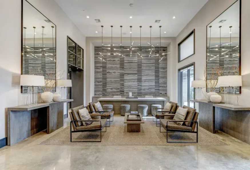 Luxurious modern living room with neutral decor, large mirrors, and symmetrical seating around a central coffee table