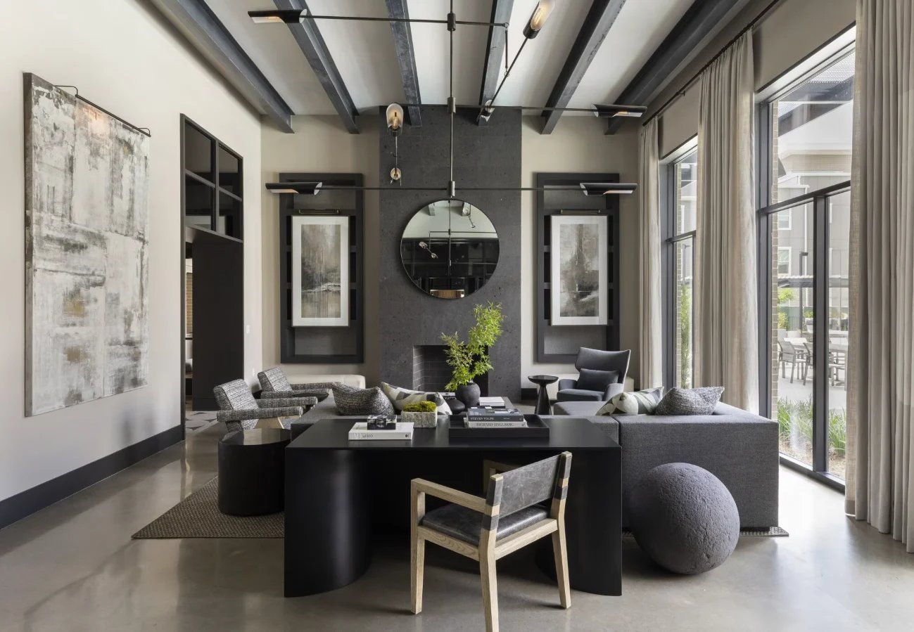 Modern dining room with a black table, patterned chairs, wall art, and large windows