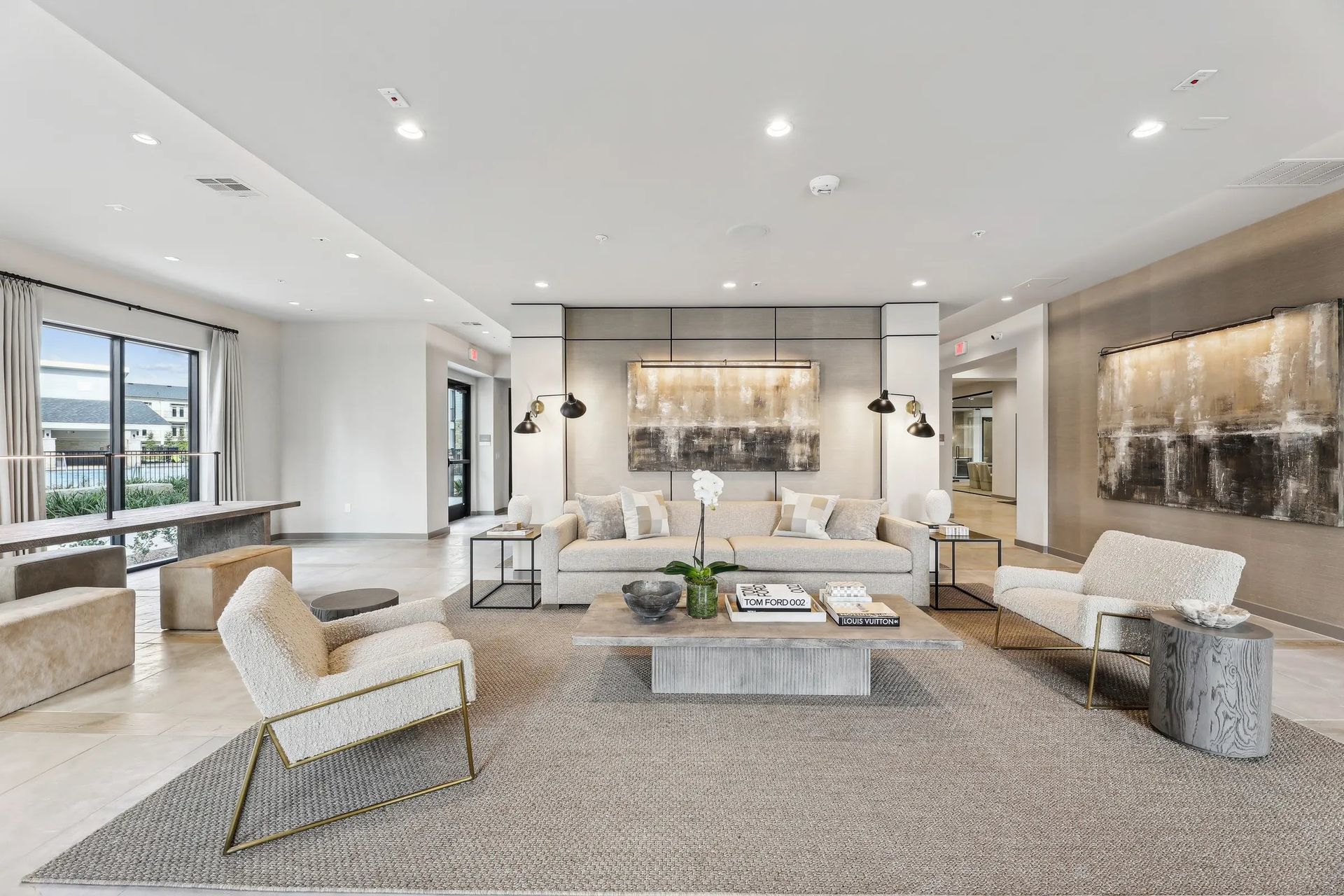 Modern luxury living room with neutral furnishings, fireplace, and large windows