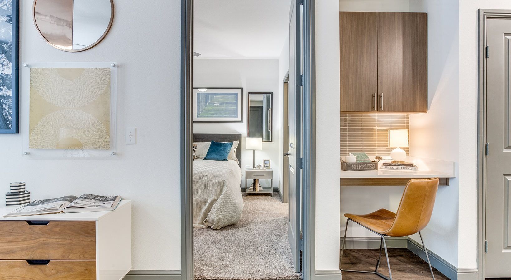Bright apartment interior with vanity, hallway to bedroom, and small kitchen workspace