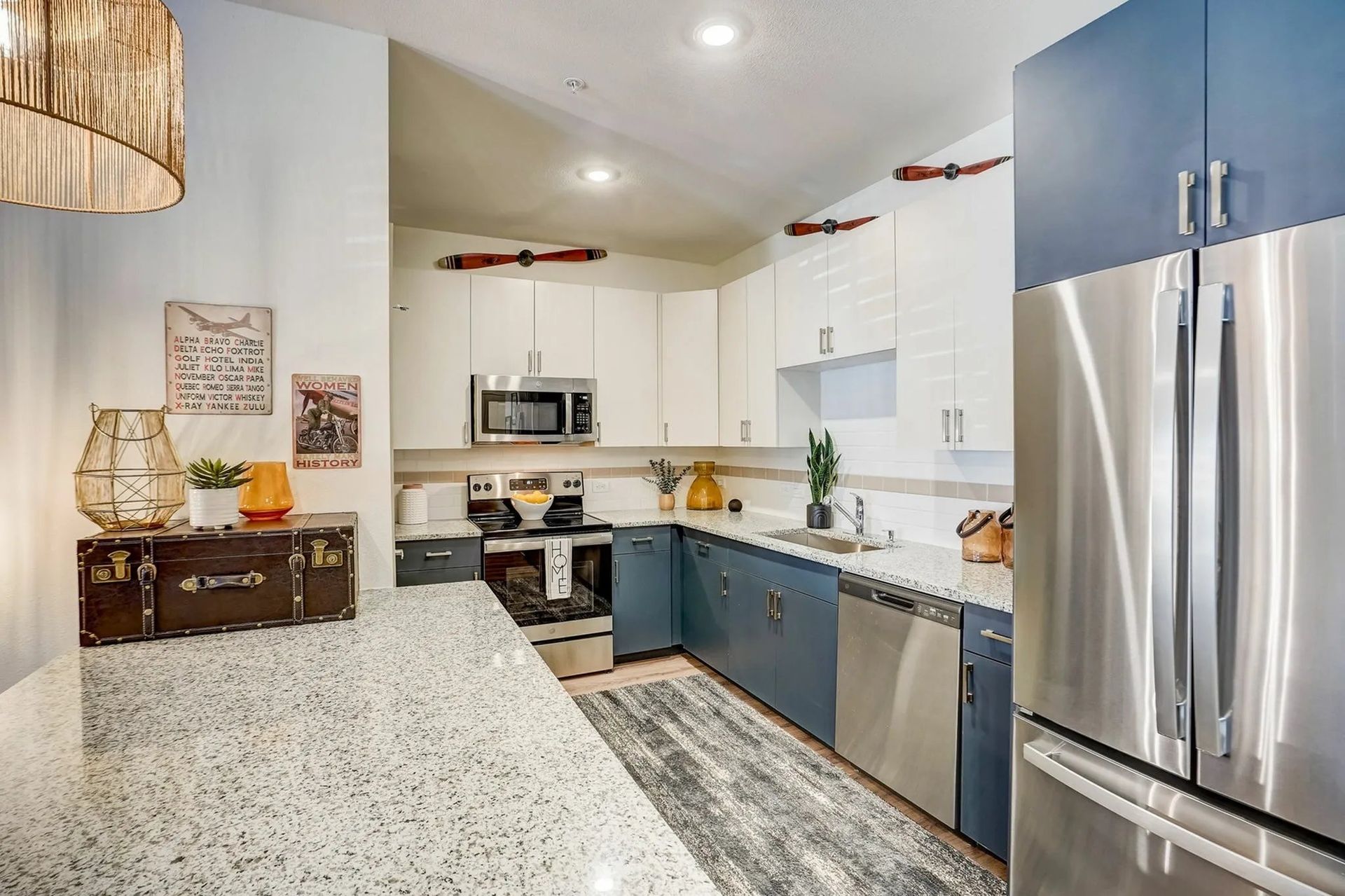 Modern kitchen with stainless steel appliances, white cabinets, and granite countertops