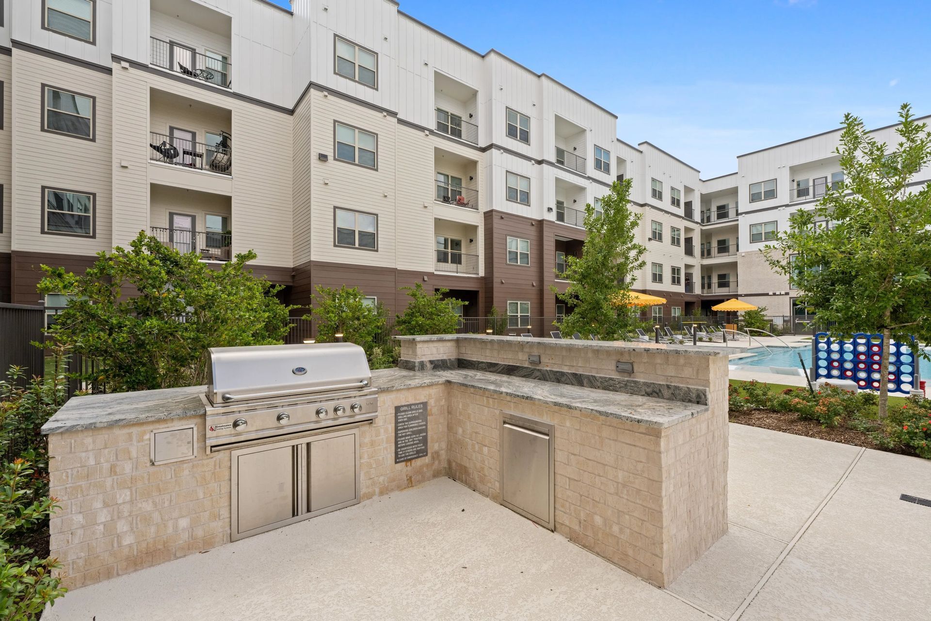 Apartment courtyard with built-in stone barbecue grills and a seating area