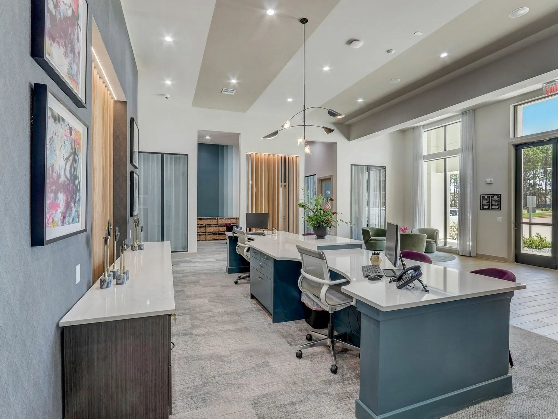 Modern dental office with blue chairs, white countertops, and large windows