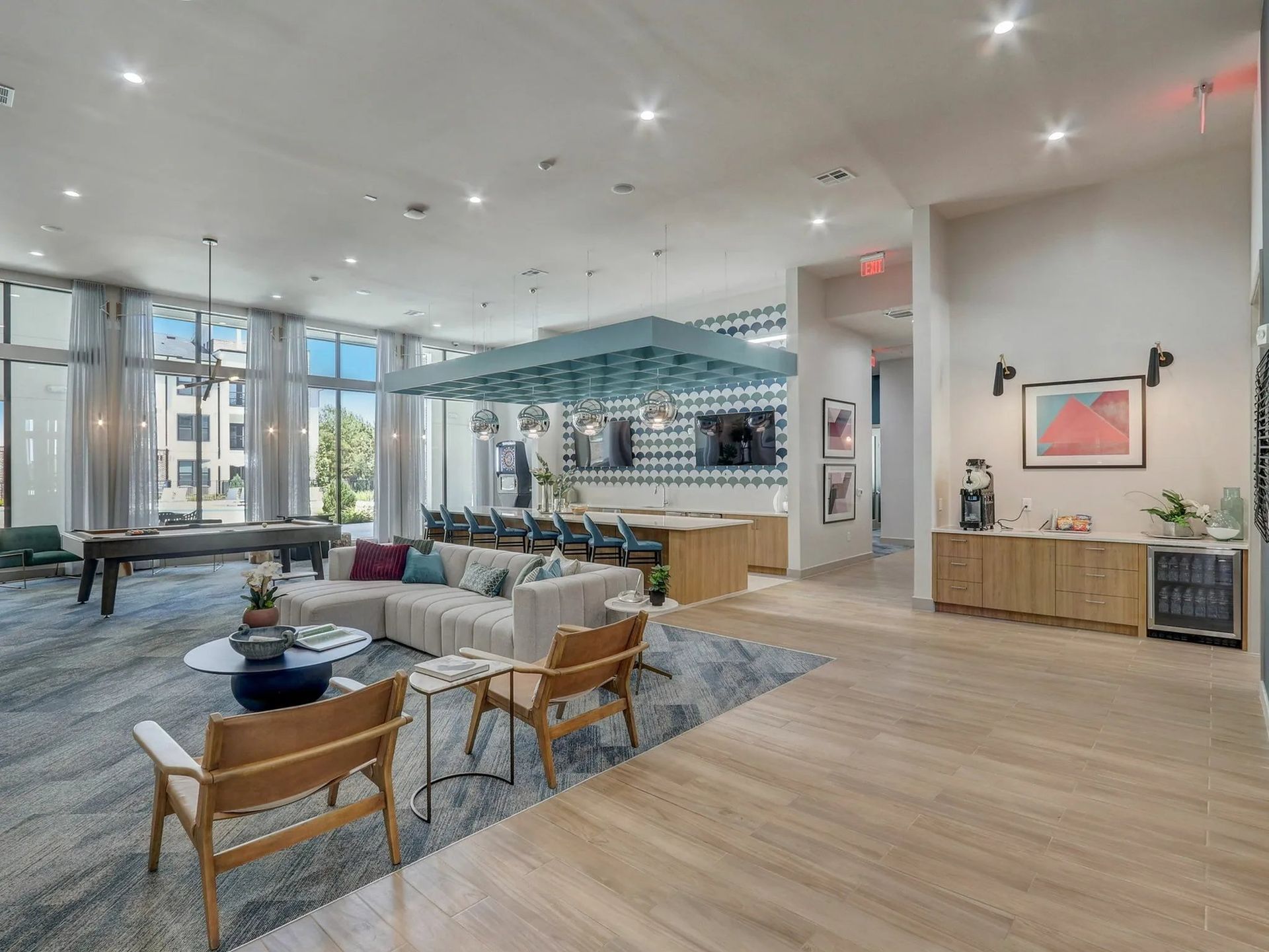 Spacious modern lobby with lounge seating, wood floors, and a reception area under bright skylights