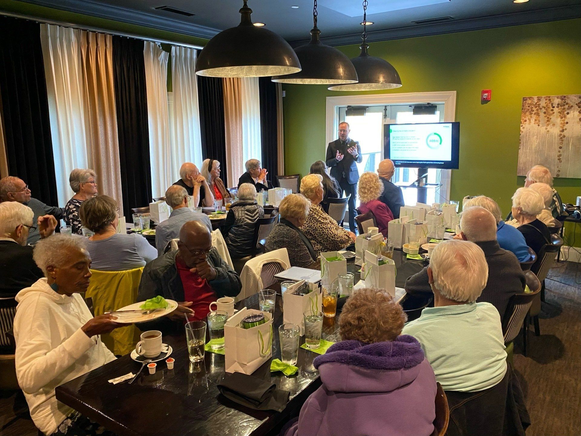 A group of people are sitting at tables in a conference room.