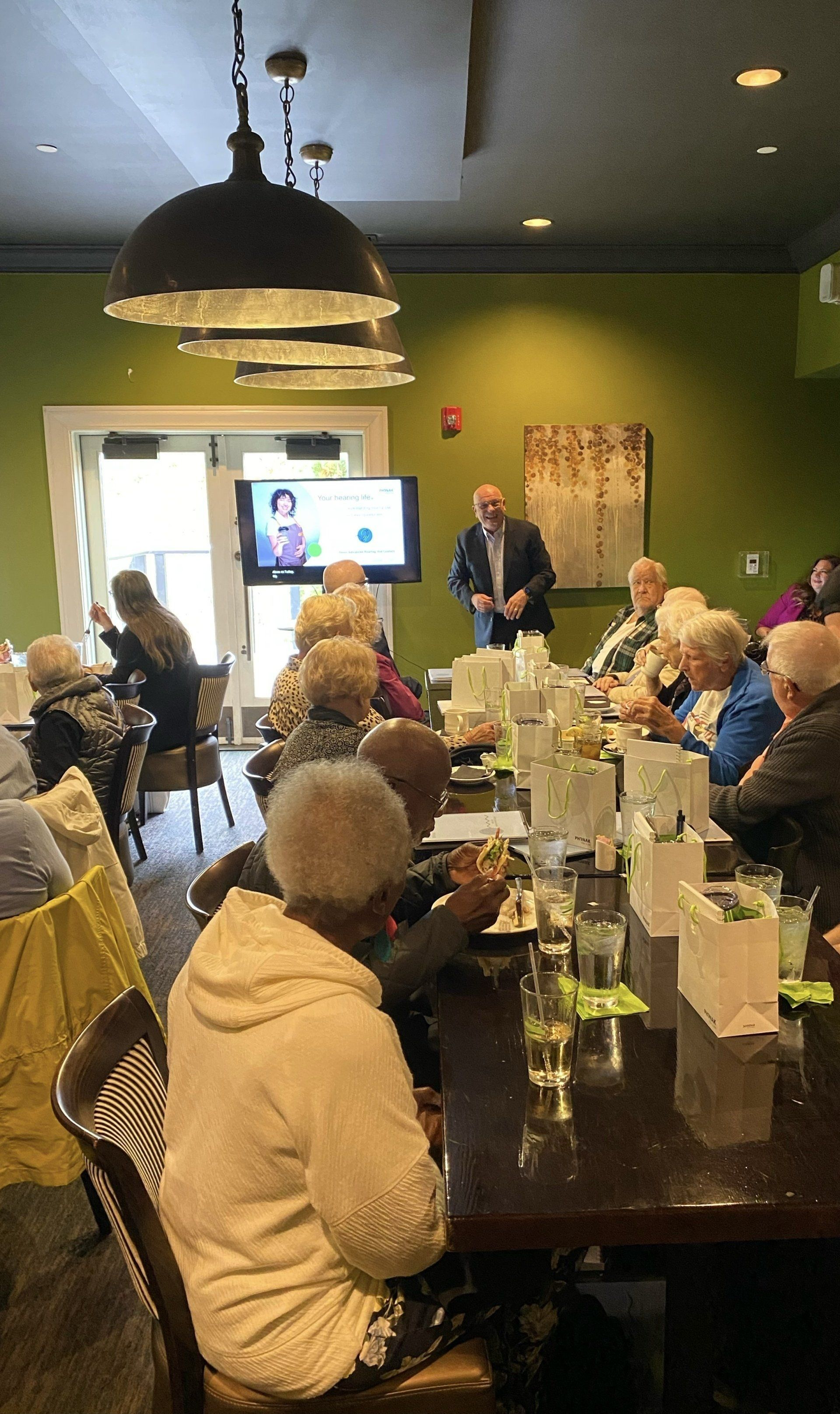 A group of people are sitting at tables in a conference room.