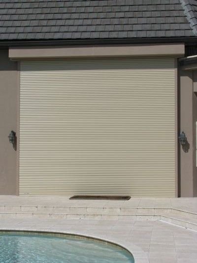 Tan roller shutter covering an outdoor opening, next to a pool.