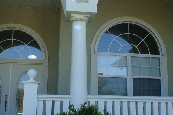 Exterior of a house with arched windows and a white porch.