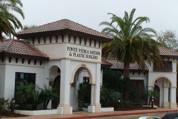 Exterior of Ponte Vedra MedSpa & Plastic Surgery building with arches and palm trees.