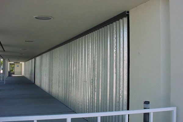 A long hallway with corrugated, translucent wall panels. Sunlight streams in.