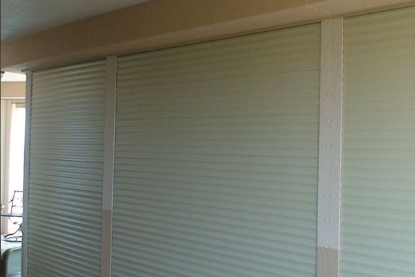 Accordion-style wall panels, light green with vertical wooden supports, beneath a beige beam.