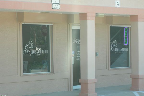 Exterior of a business with glass windows and a door. Signage on the windows reads 