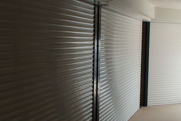 Gray and white corrugated roller shutters on a building.