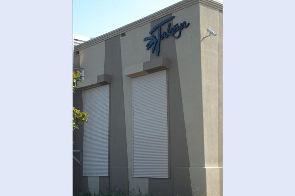 Building exterior with closed white shutters and blue 