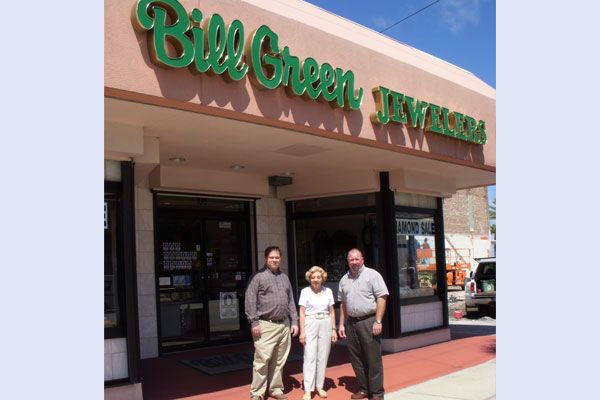 Three people stand outside 