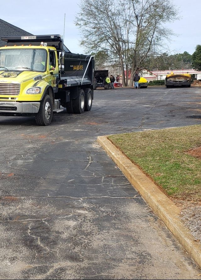 A yellow dump truck is parked in a parking lot.