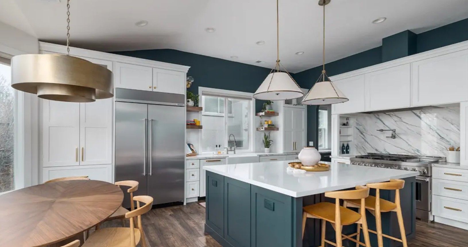 Bright modern kitchen with white cabinets, teal island, marble backsplash, and pendant lights