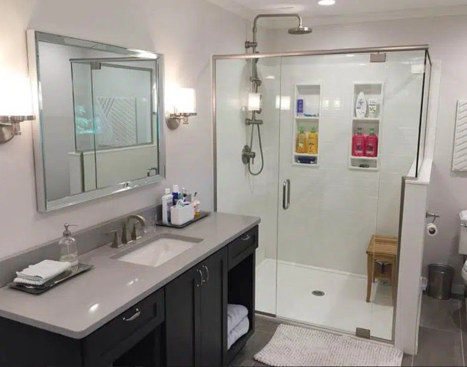 Accessible bathroom with sink, mirror, and roll-in shower with bench and grab bars