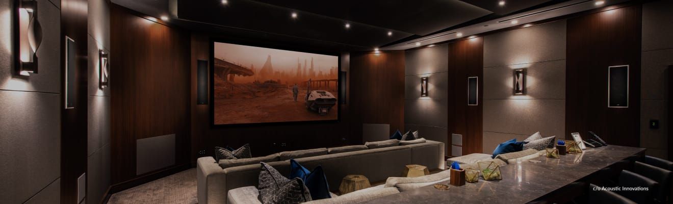 A home theater with a large screen and a long table.