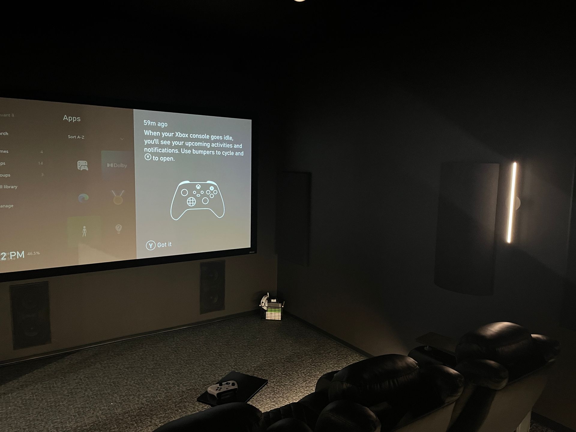 A projector screen in a dark room with a controller on it