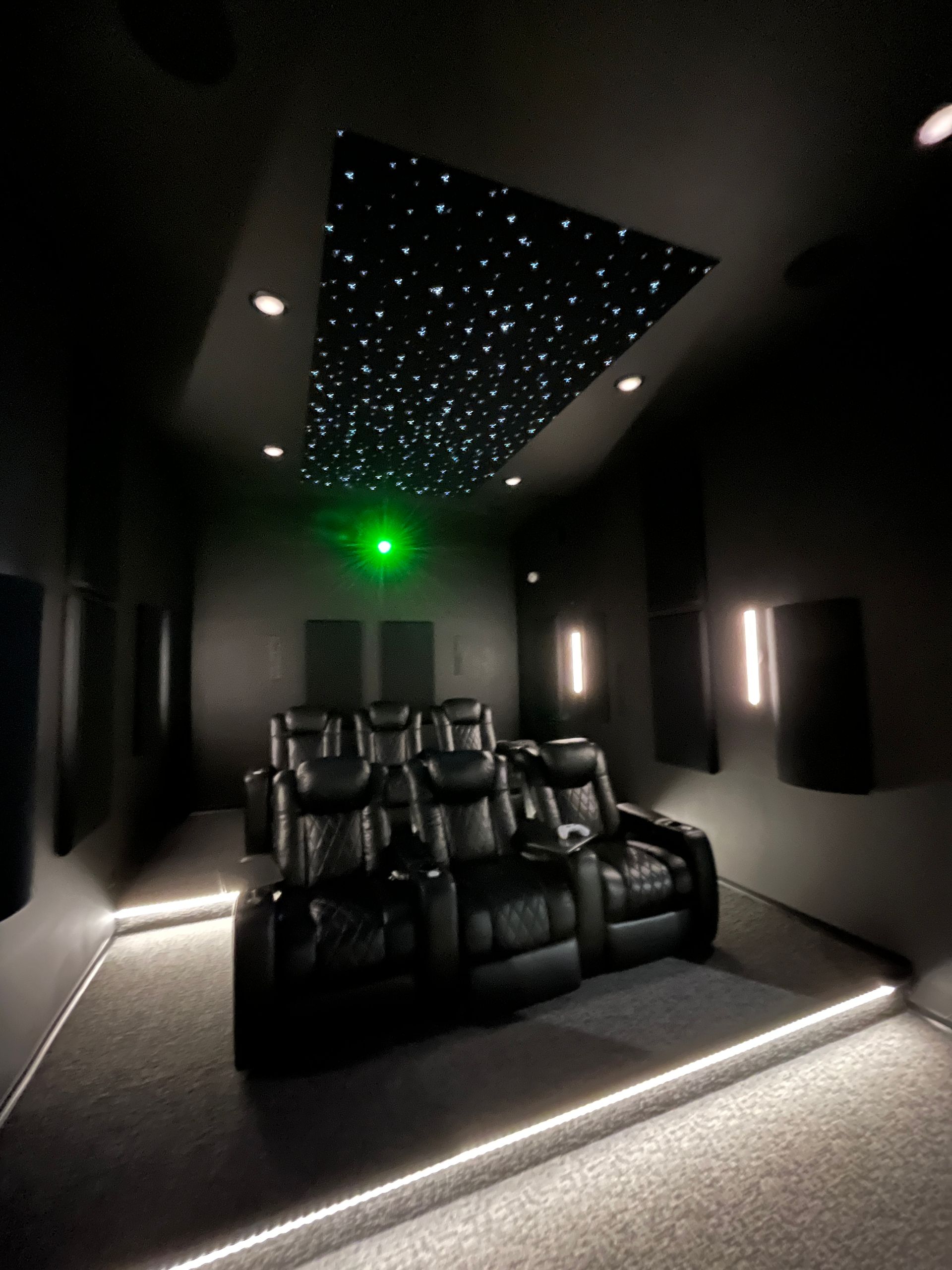 A dark room with a green light on the ceiling