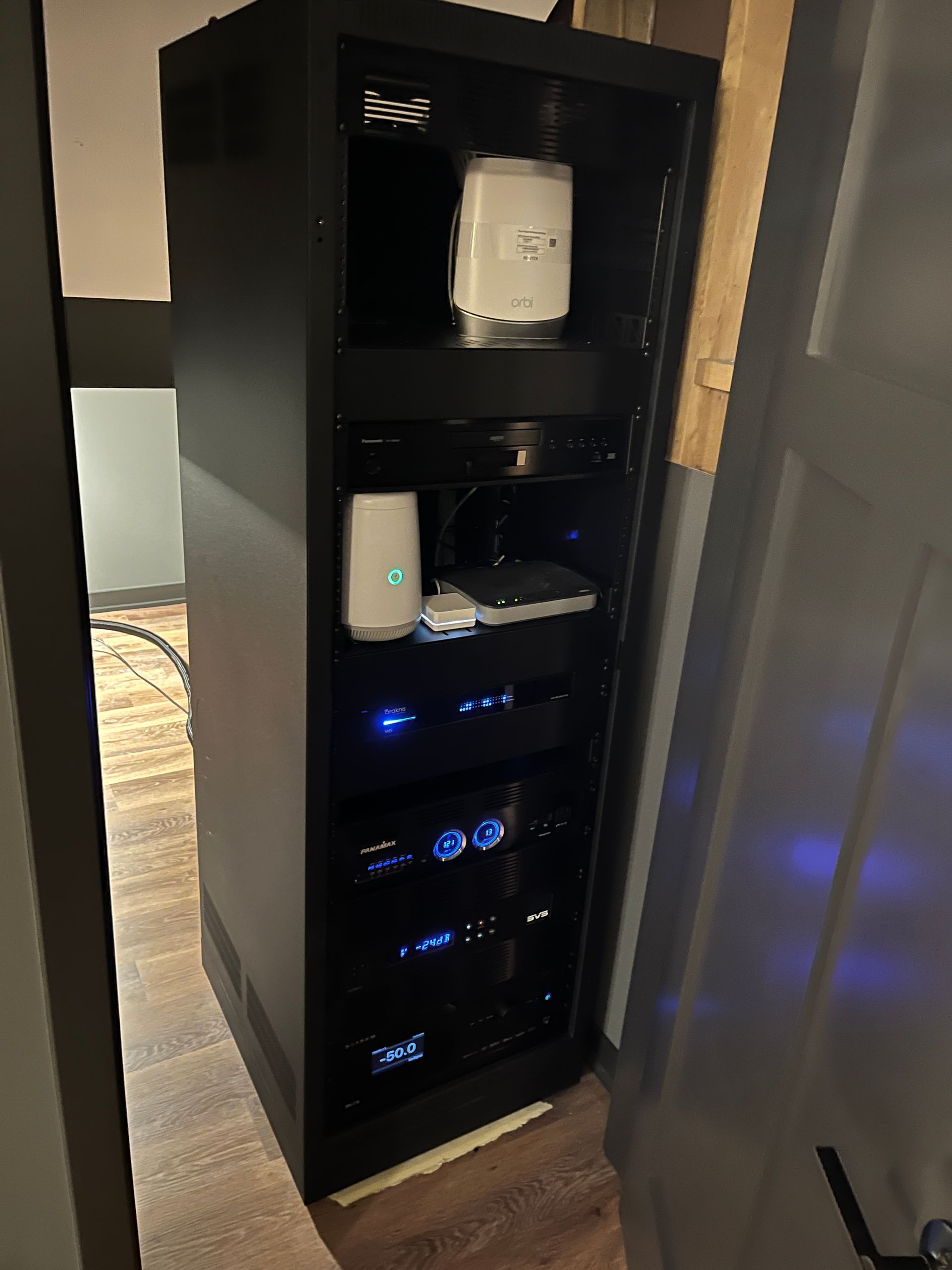 A black cabinet with a lot of electronic equipment on it.