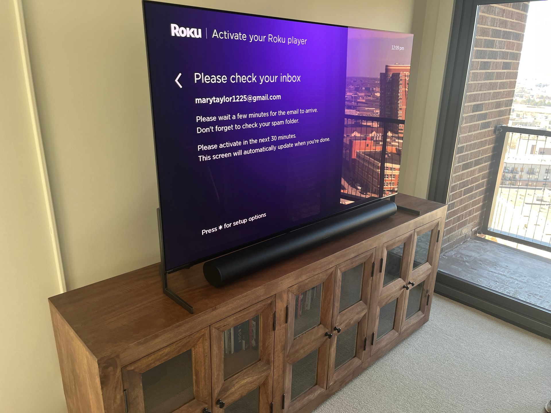 A flat screen tv is sitting on top of a wooden entertainment center.
