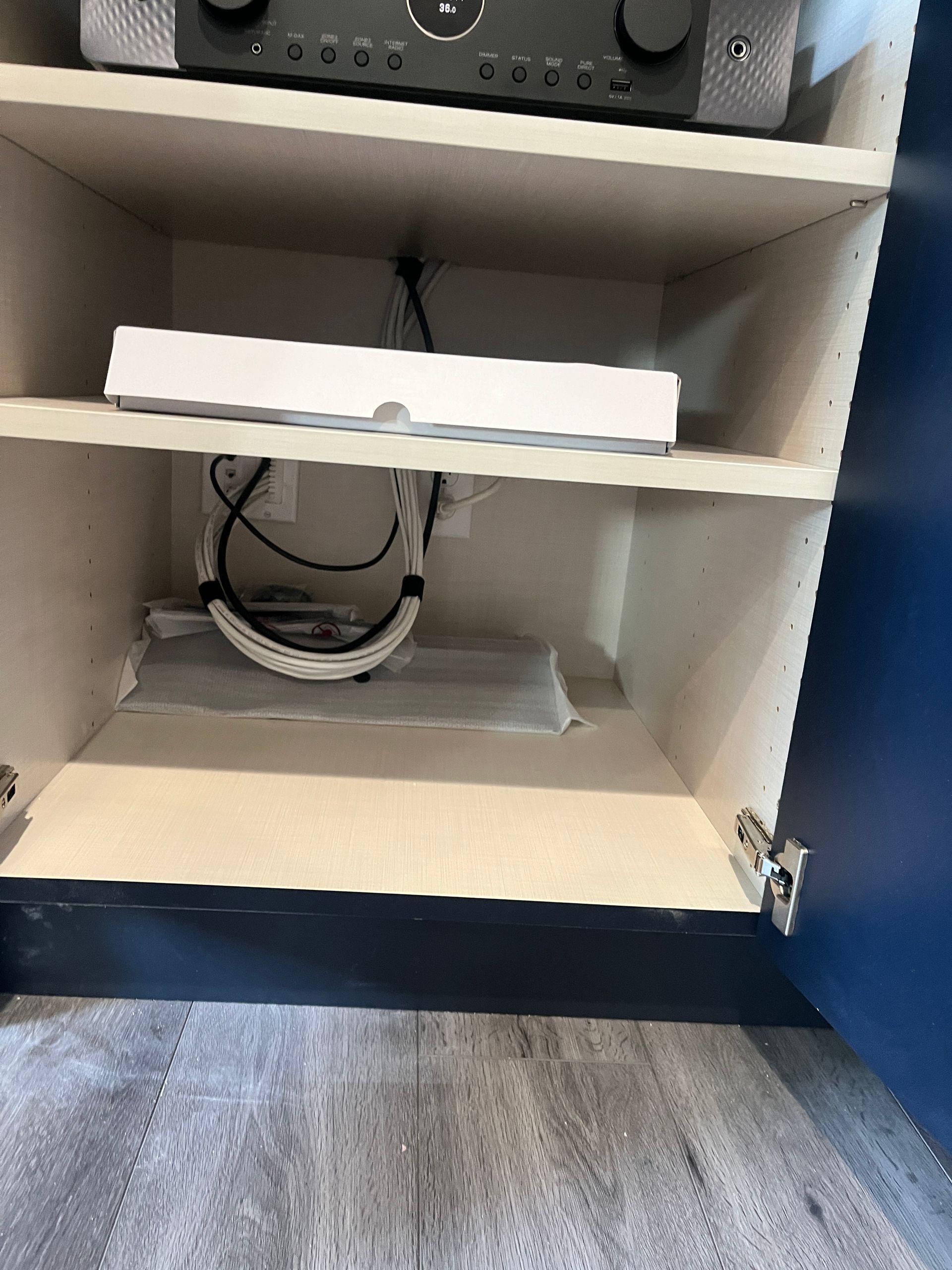 A box is sitting on top of a shelf in a cabinet.