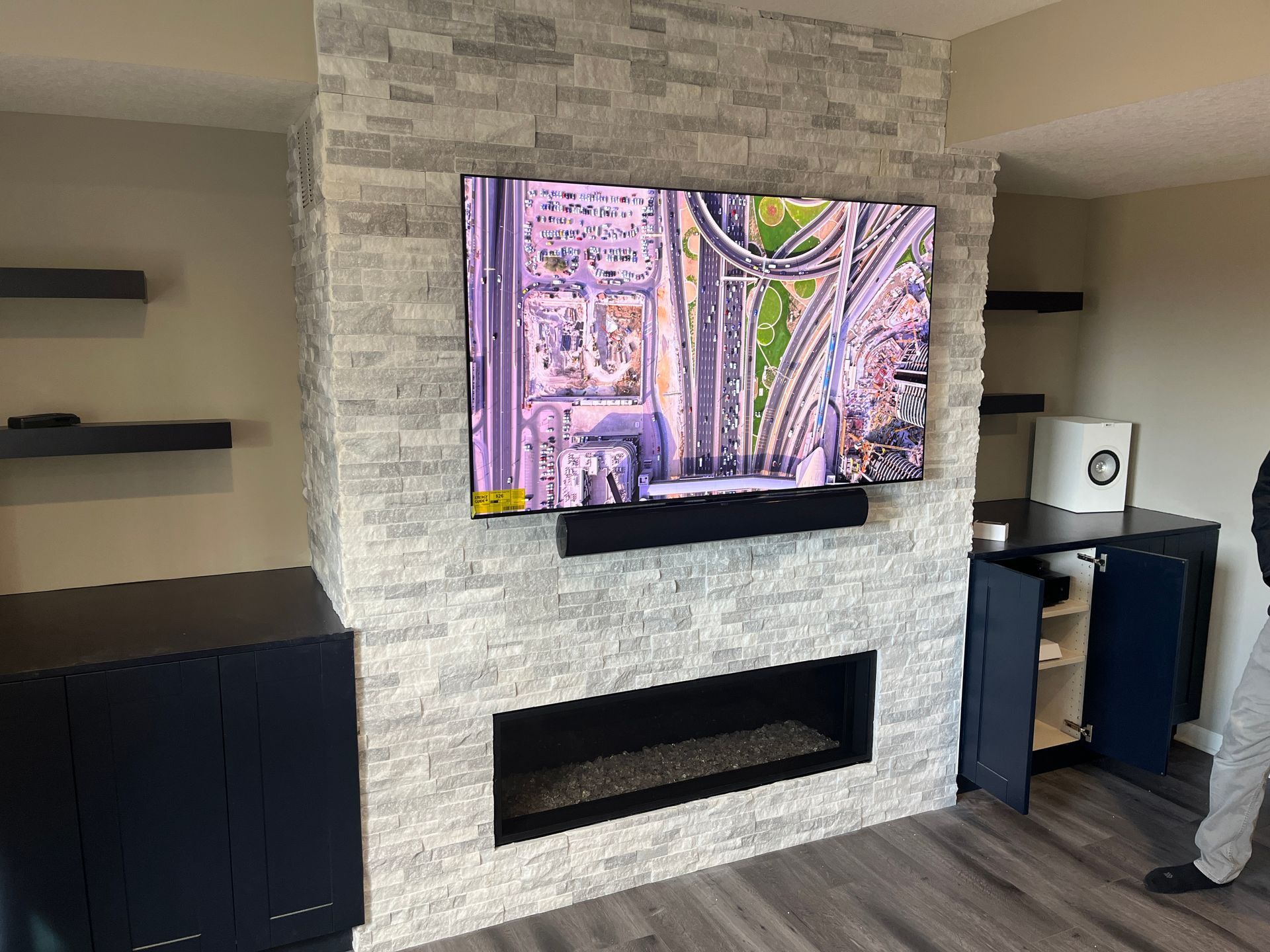 A living room with a fireplace and a flat screen tv mounted on the wall.