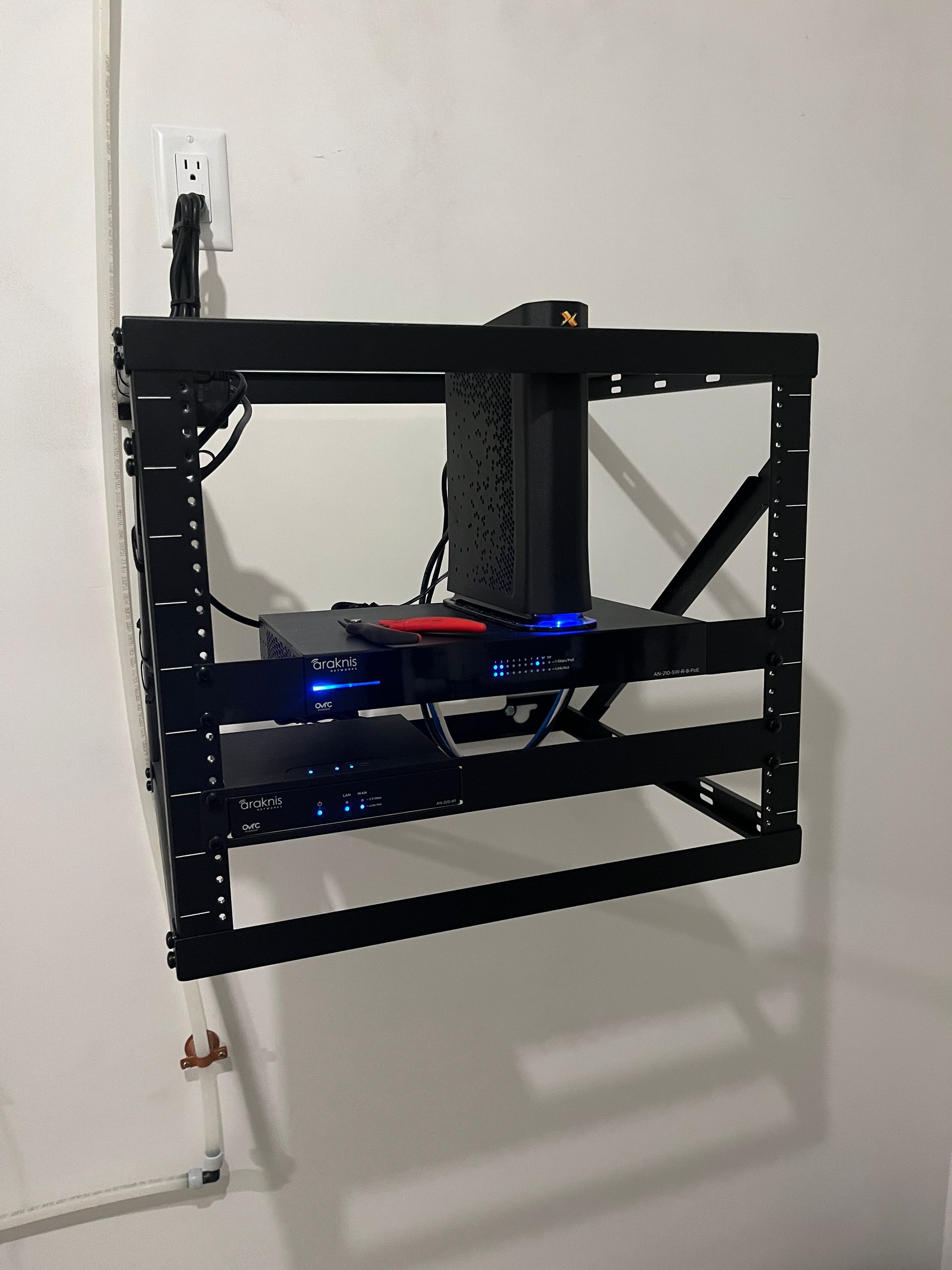 A computer is sitting on top of a rack on a wall.