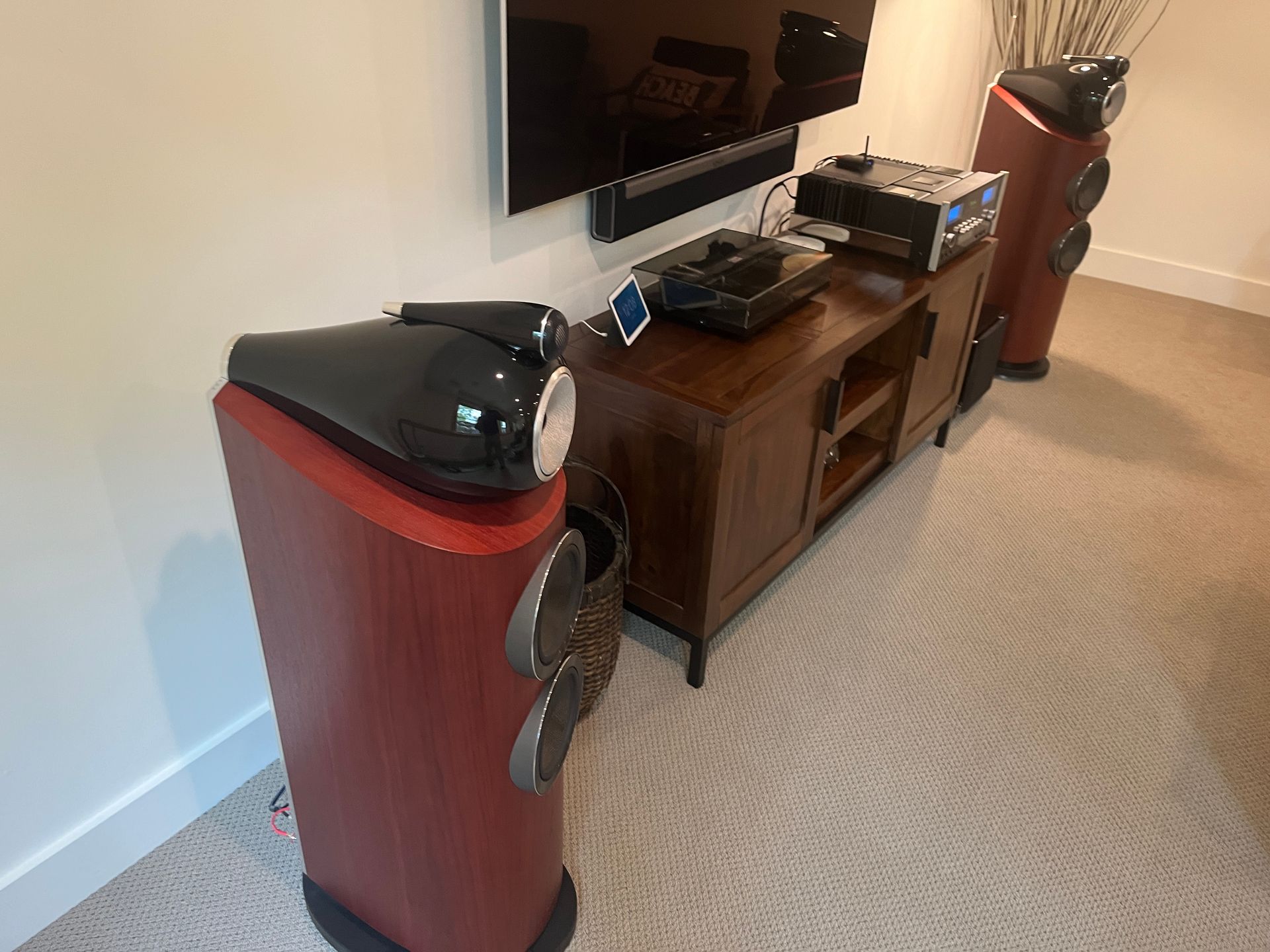 A living room with two speakers and a television on the wall.