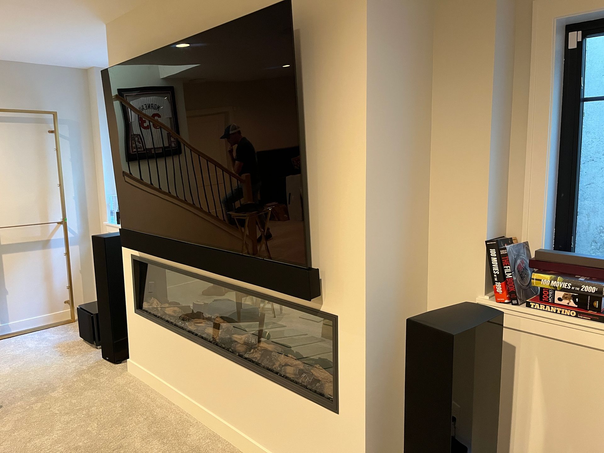 A living room with a fireplace and a flat screen tv on the wall.