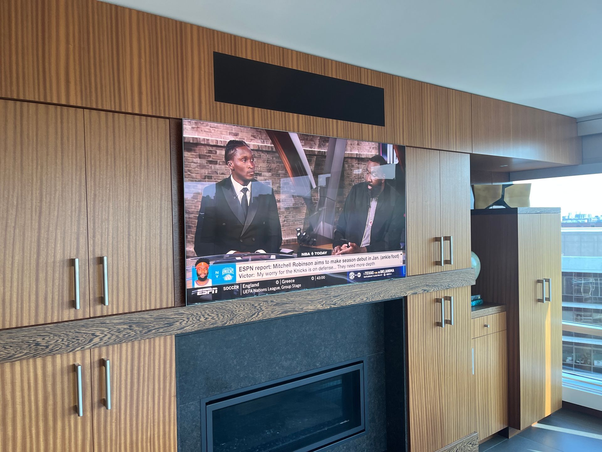 A flat screen tv is mounted above a fireplace in a living room.