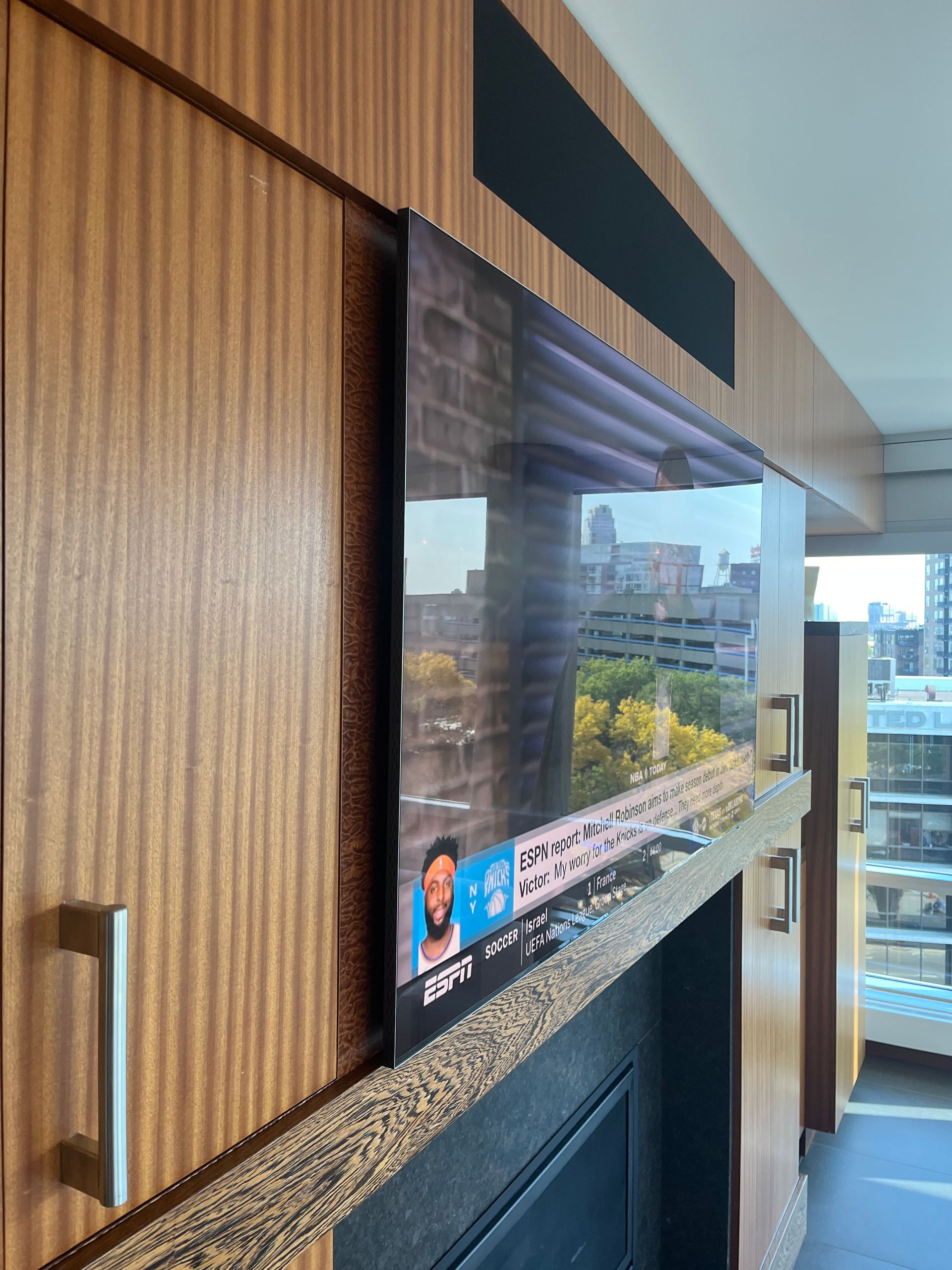 A flat screen tv is mounted above a fireplace