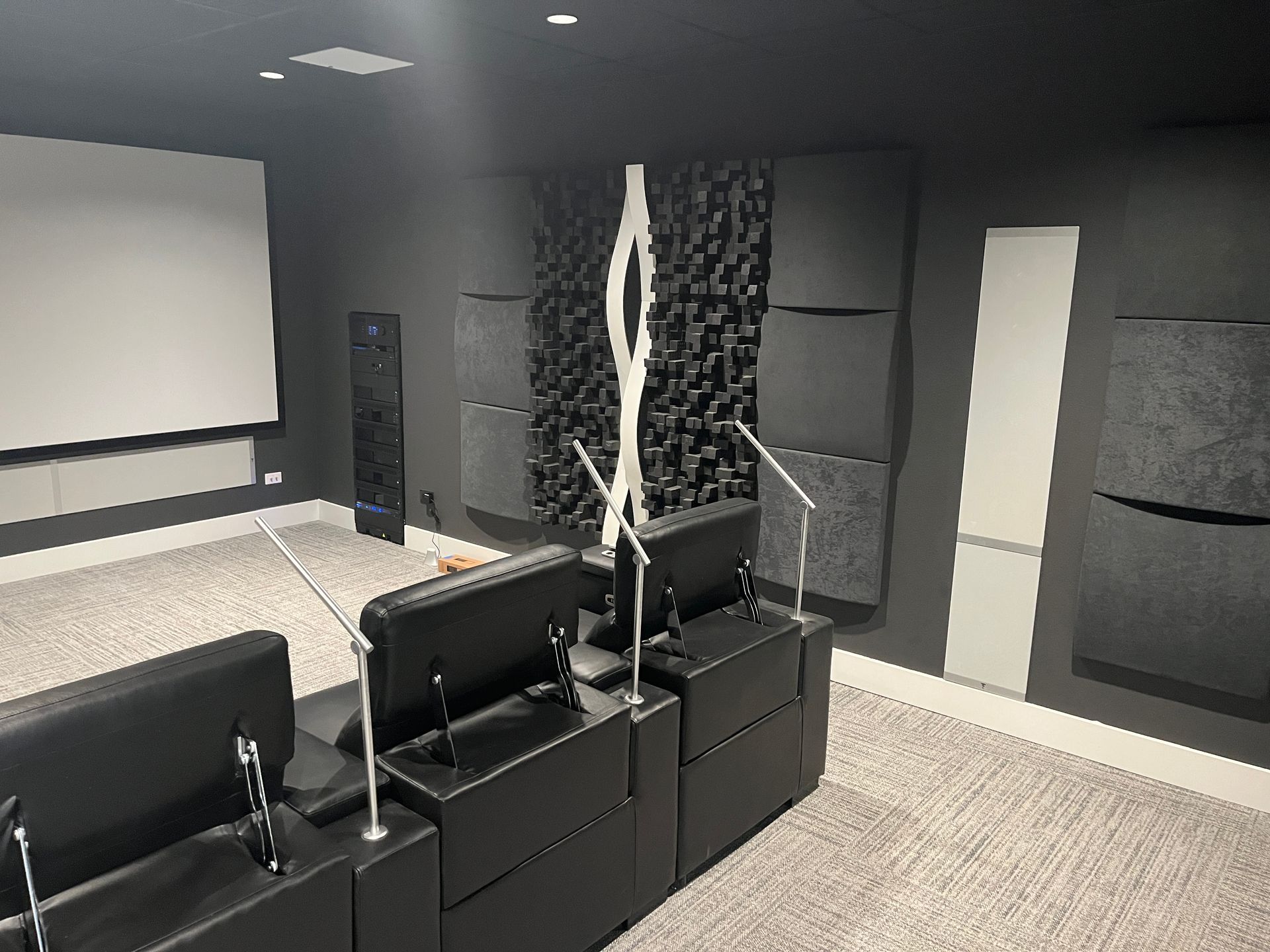 A black and white room with a projector screen