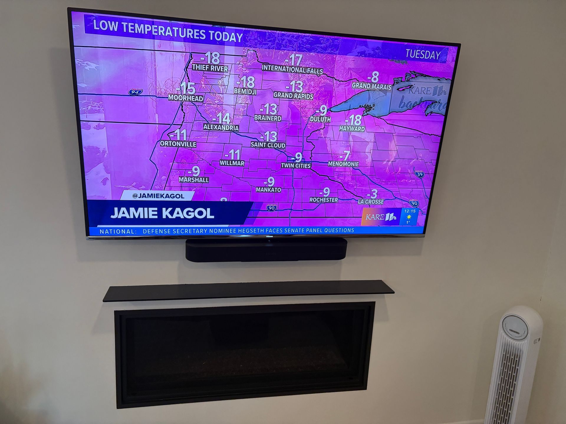 A flat screen tv is hanging on a wall next to a fireplace.