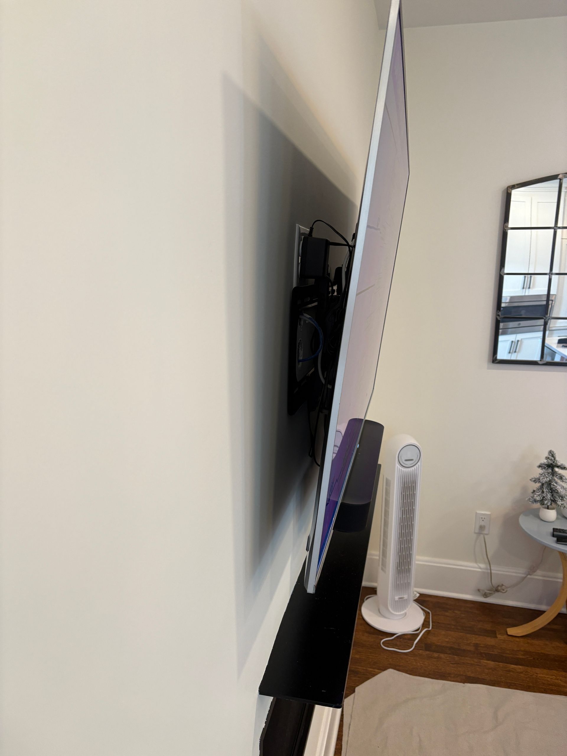 A flat screen tv is mounted on a wall in a living room.