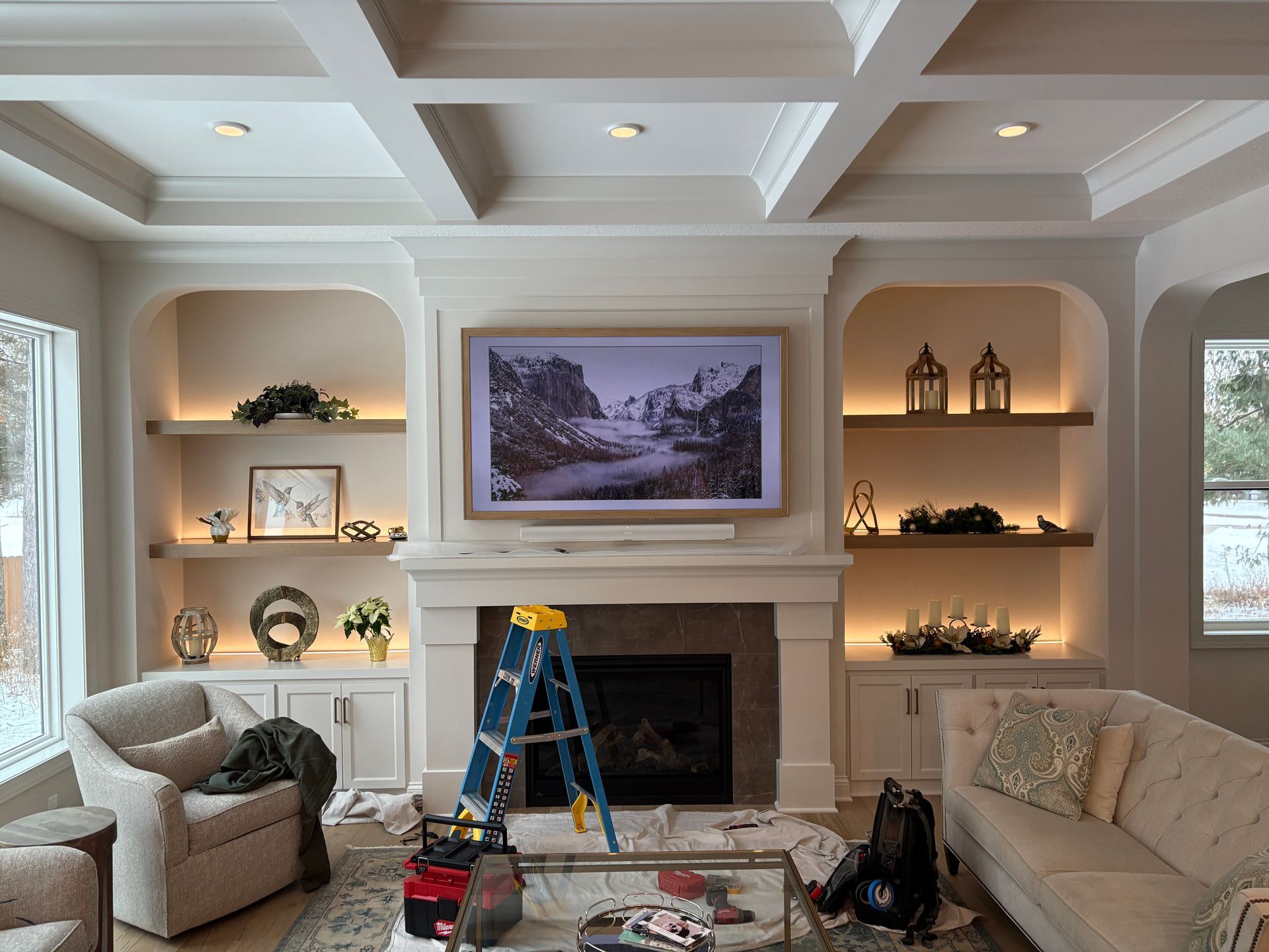 A living room with a fireplace and a flat screen tv on the wall.