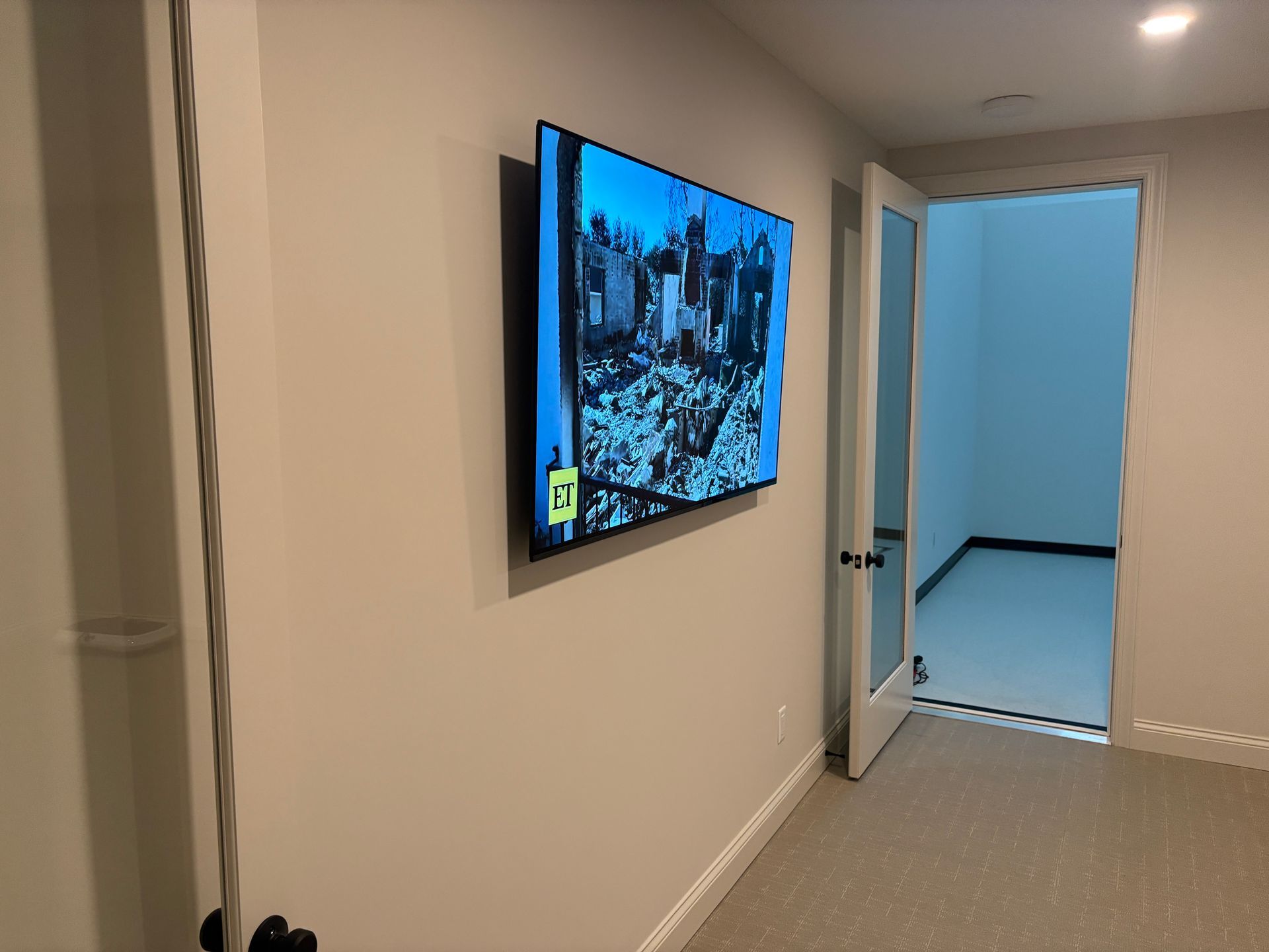 A flat screen tv is hanging on a wall in a room.