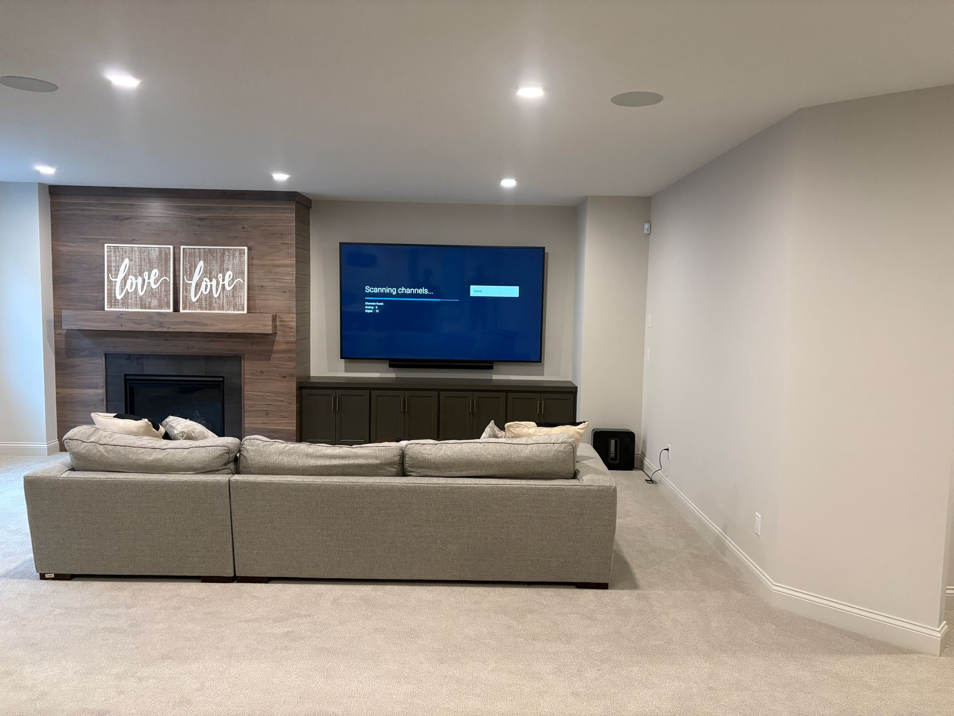 A living room with a couch , television and fireplace.