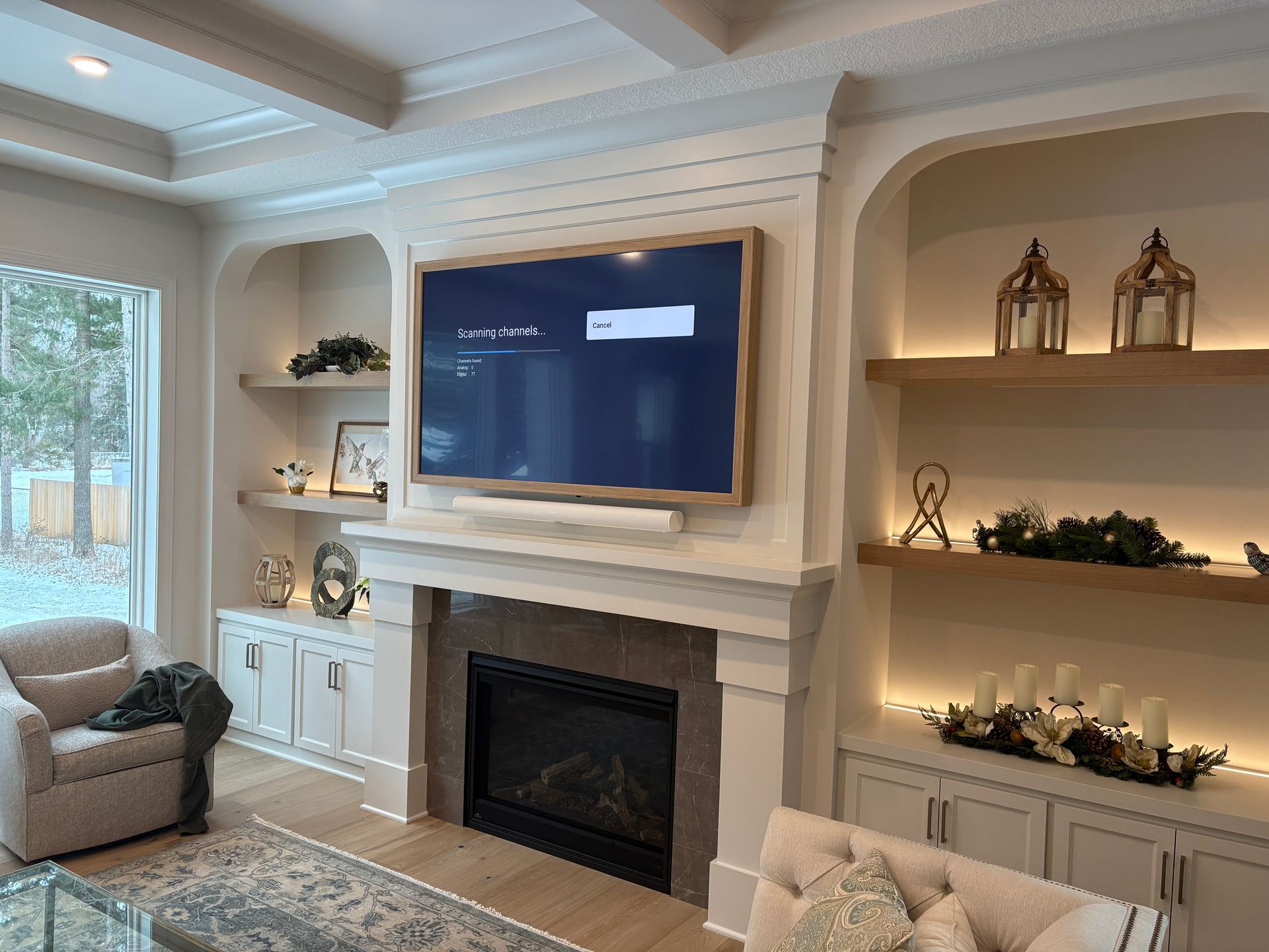 A living room with a fireplace and a flat screen tv on the wall.