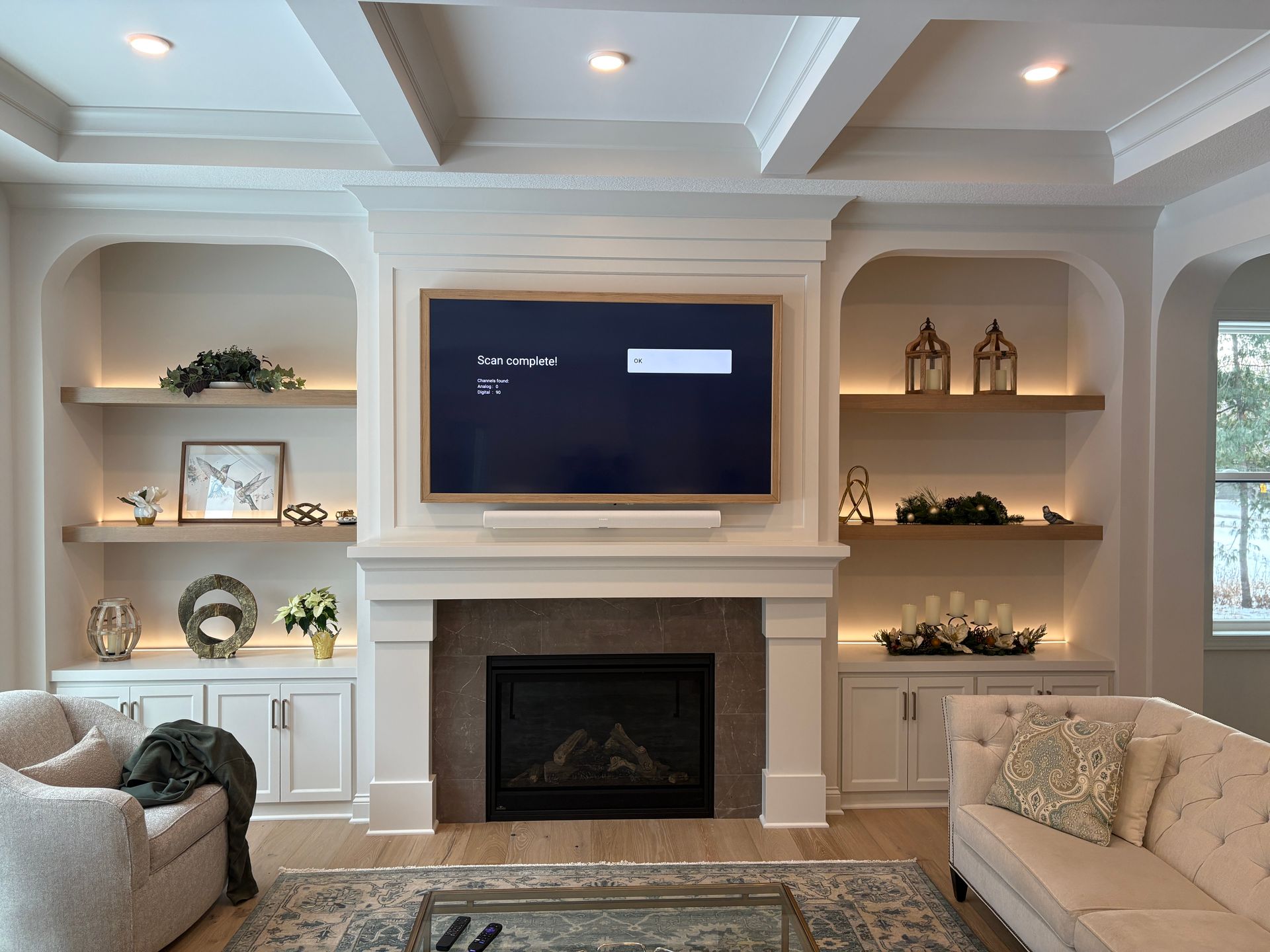 A living room with a fireplace and a flat screen tv on the wall.
