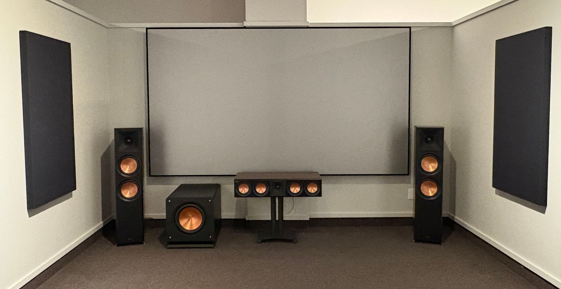 A room with speakers and a projector screen
