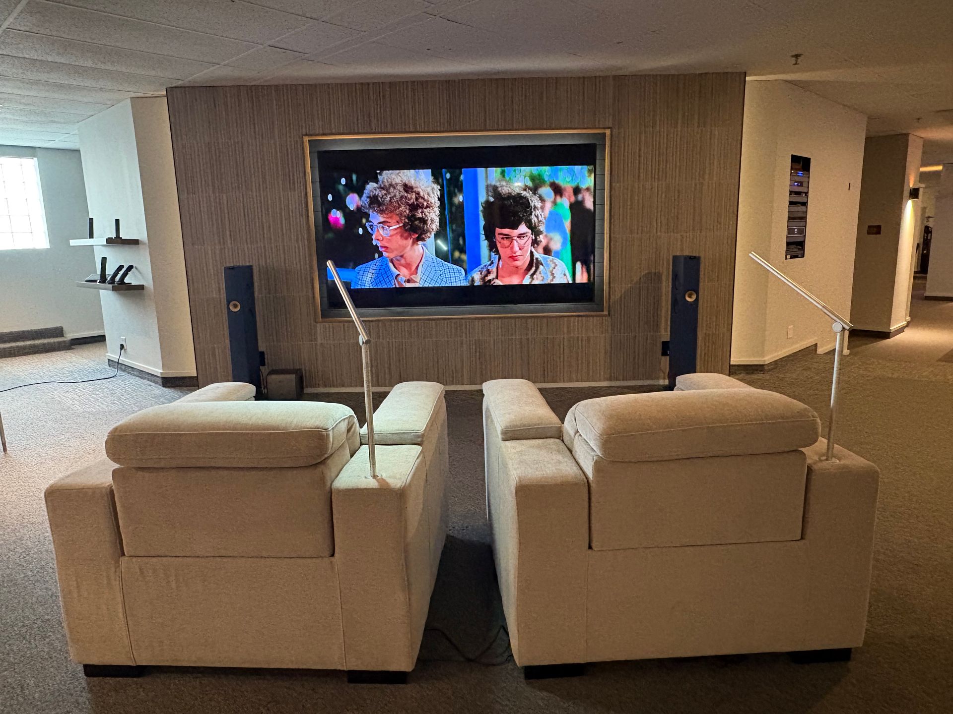 A living room with two chairs and a flat screen tv.