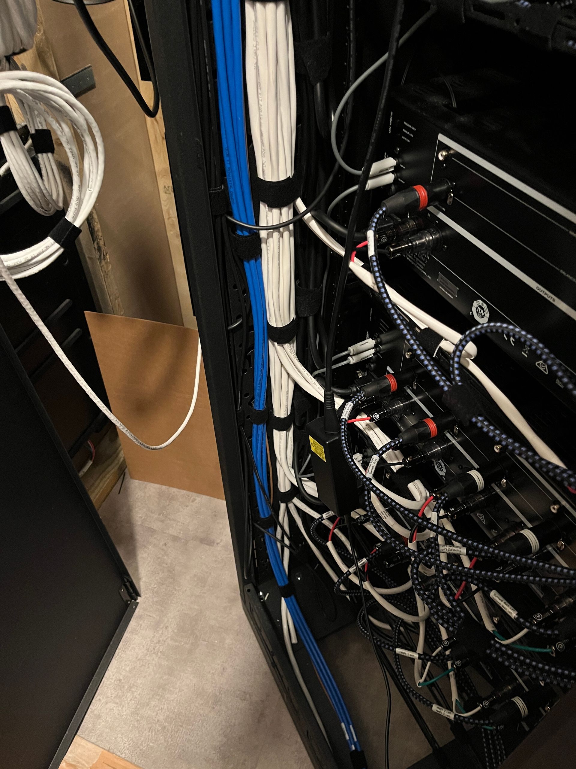 A bunch of wires are hanging from a rack in a room.