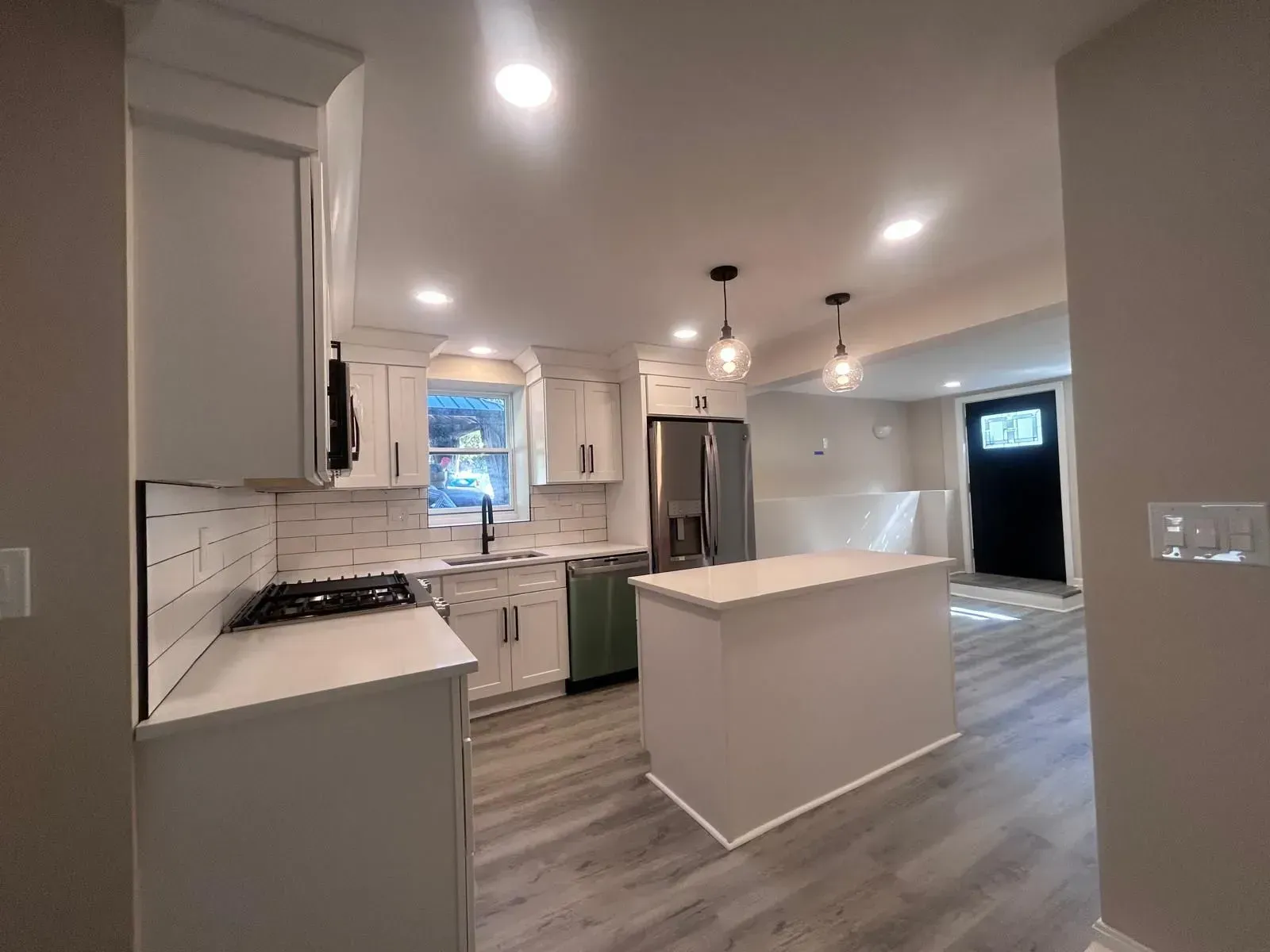 Newly renovated kitchen with white cabinets, island, and stainless steel appliances.